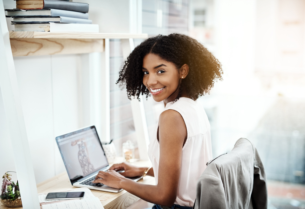 A young woman working on her laptop looking for online editing jobs